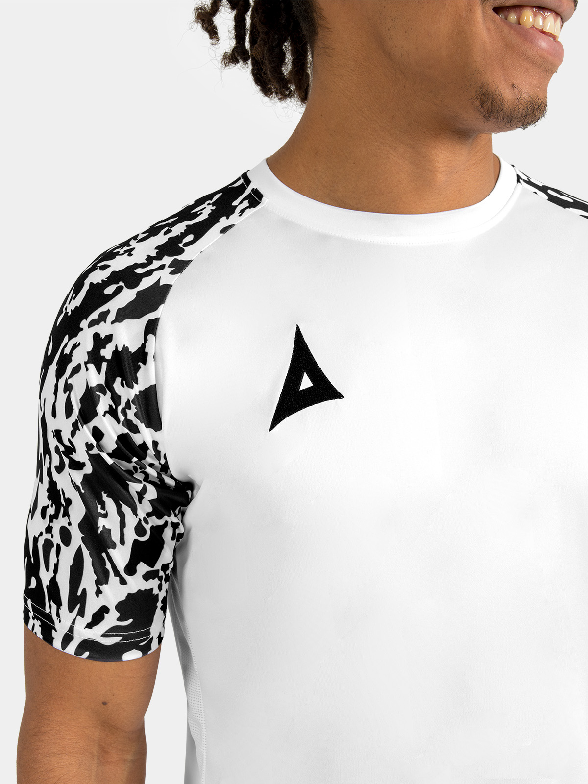 	detailed shot of the durable ribbed round collar and internal neck branding on the white and black jersey.
