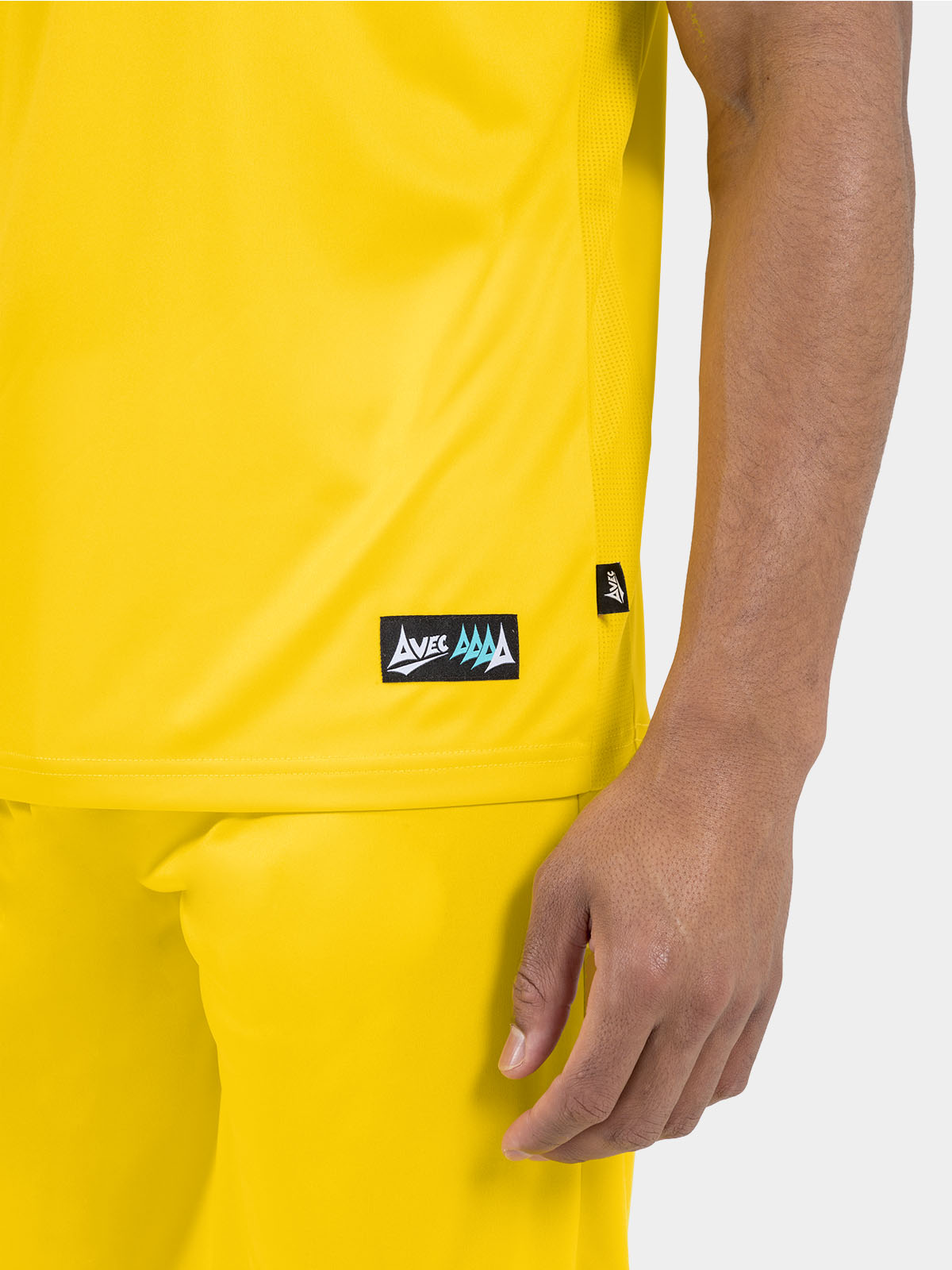 	side seam detail of the yellow jersey, showing the moisture-managing mesh inserts and woven authentic id label.