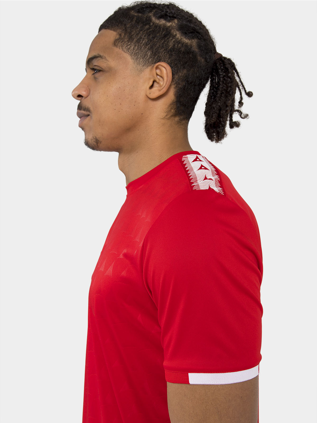 	technical detail of the red jersey shoulder featuring the heritage 'a' logo tape.