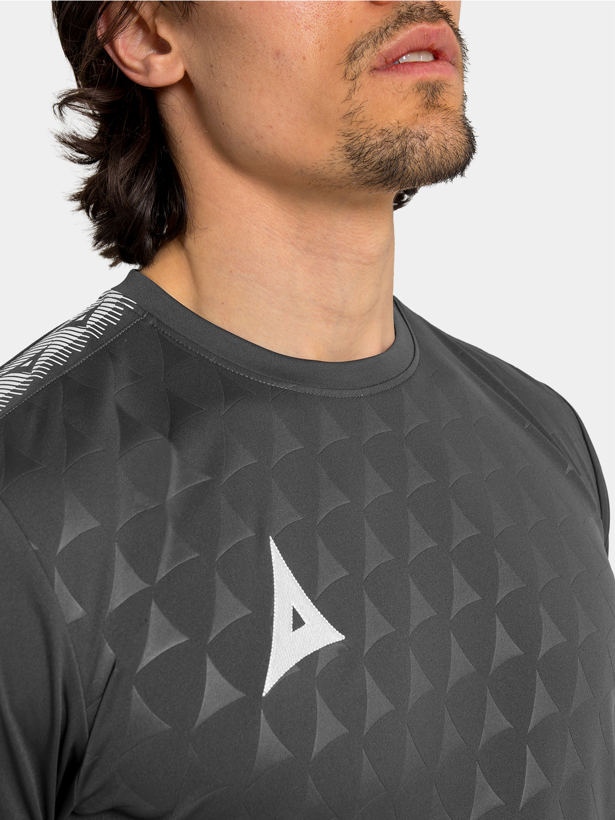 	close-up perspective of the unique repeating debossed 'a' graphic on the charcoal front panel.