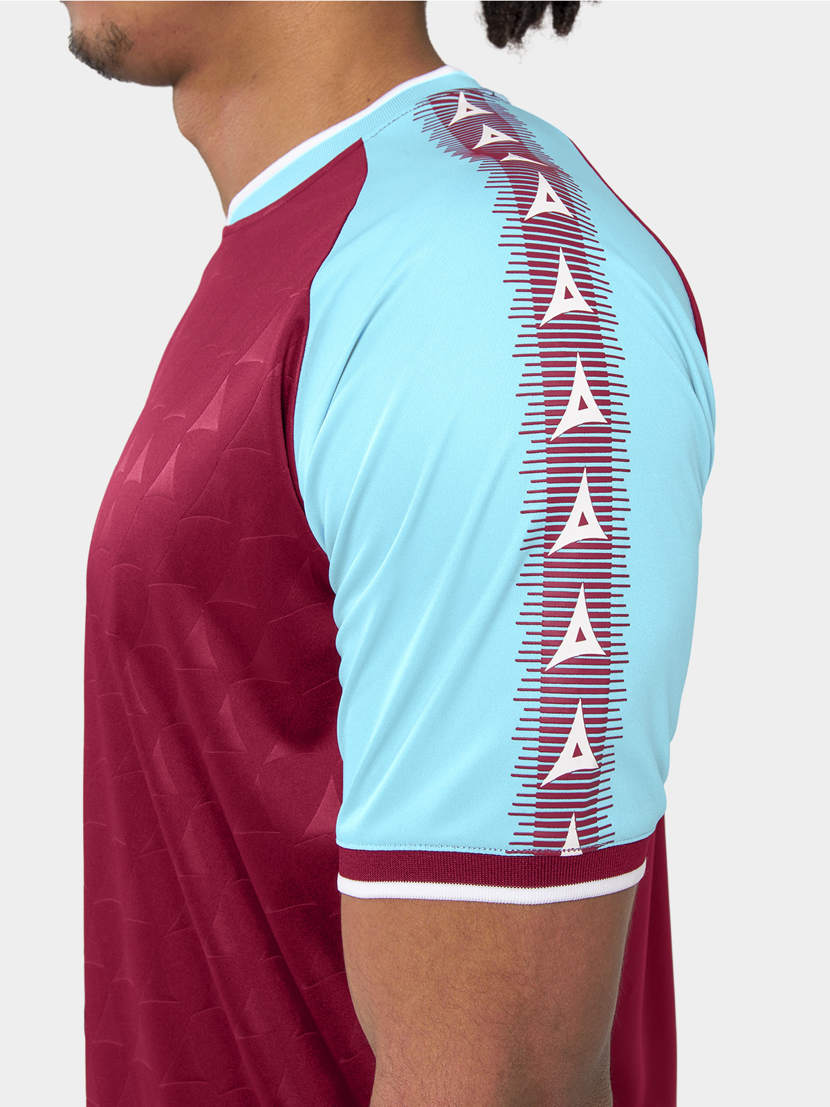 	shoulder detail of the claret heritage jersey with sky blue branding.