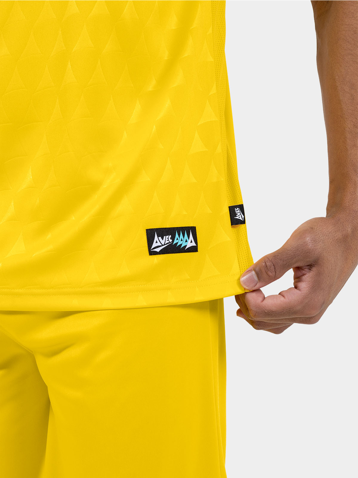 	lower hem detail of the yellow heritage jersey showing the authenticity label and side mesh ventilation.
