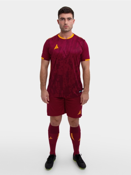 	A model standing up wearing a claret / maroon football shirt, claret Shorts and claret Football Socks.