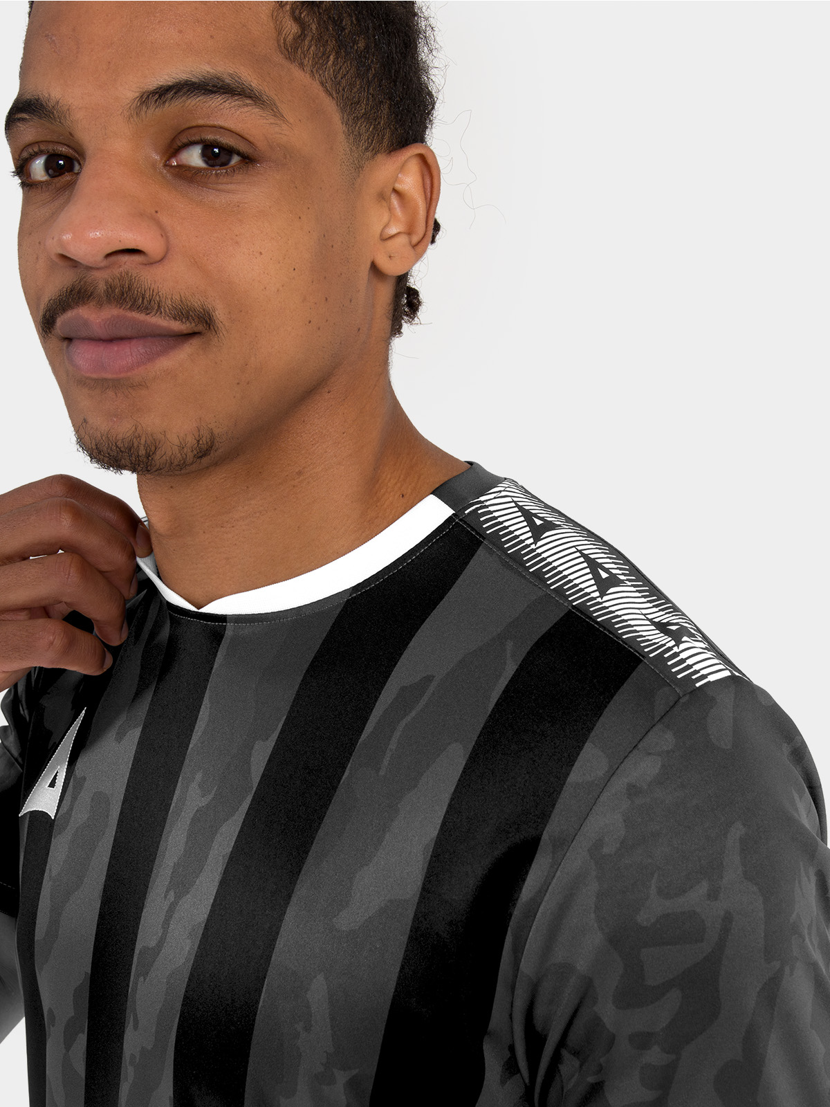 	close-up of the contrast avec heritage ‘a’ shoulder design on the anthracite grey striped football shirt.