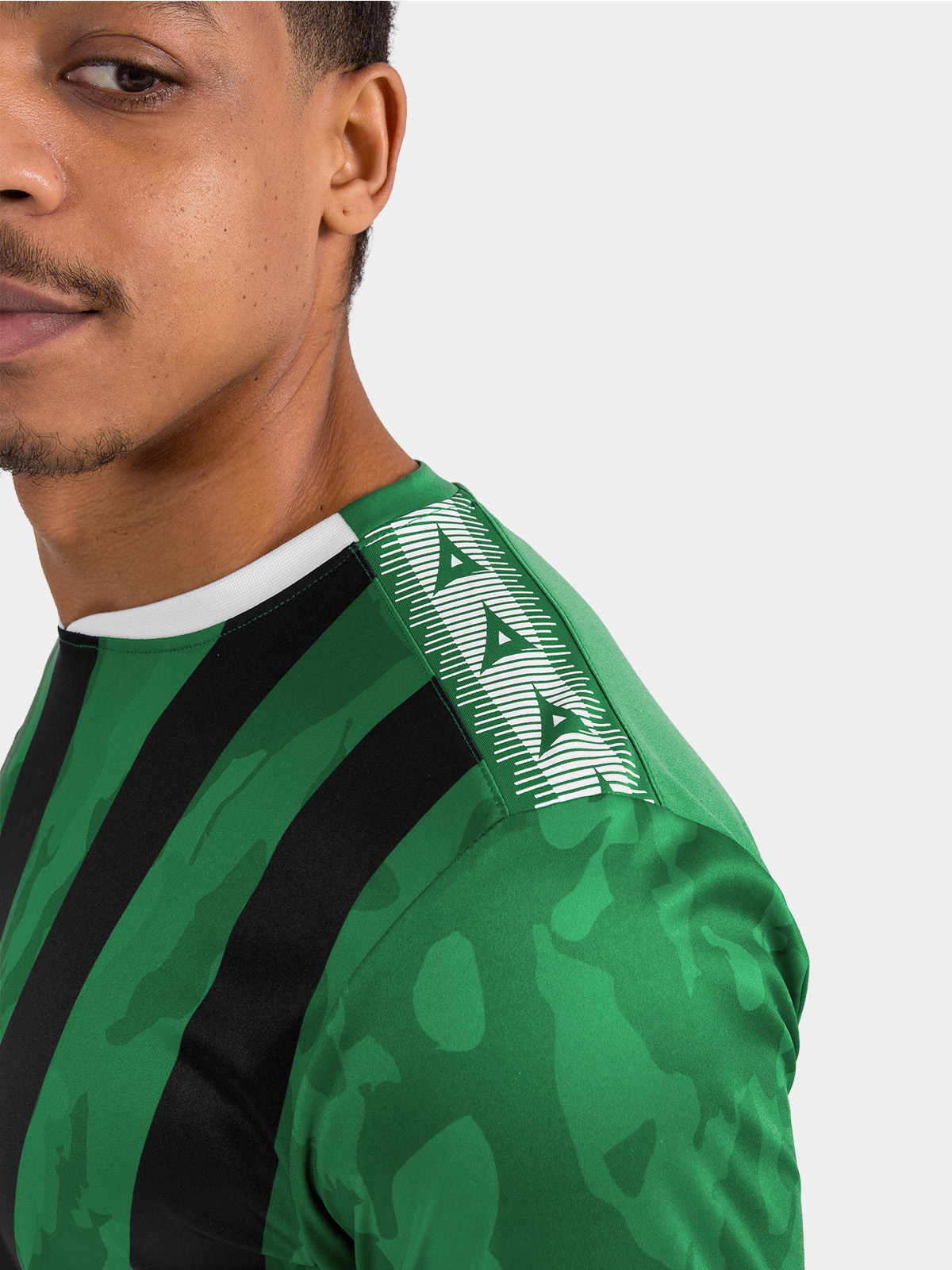 	close-up of the contrast avec heritage ‘a’ shoulder design on the green and black striped team shirt.