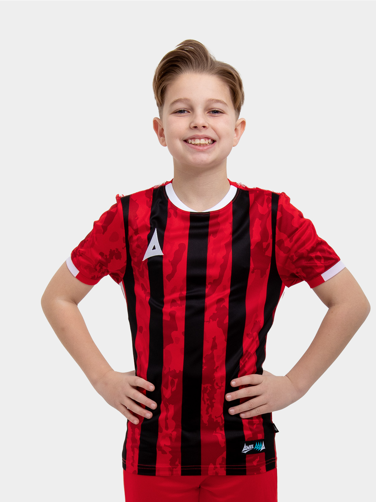 	a young child is wearing a red and black striped football shirt. the football shirt has a camo pattern