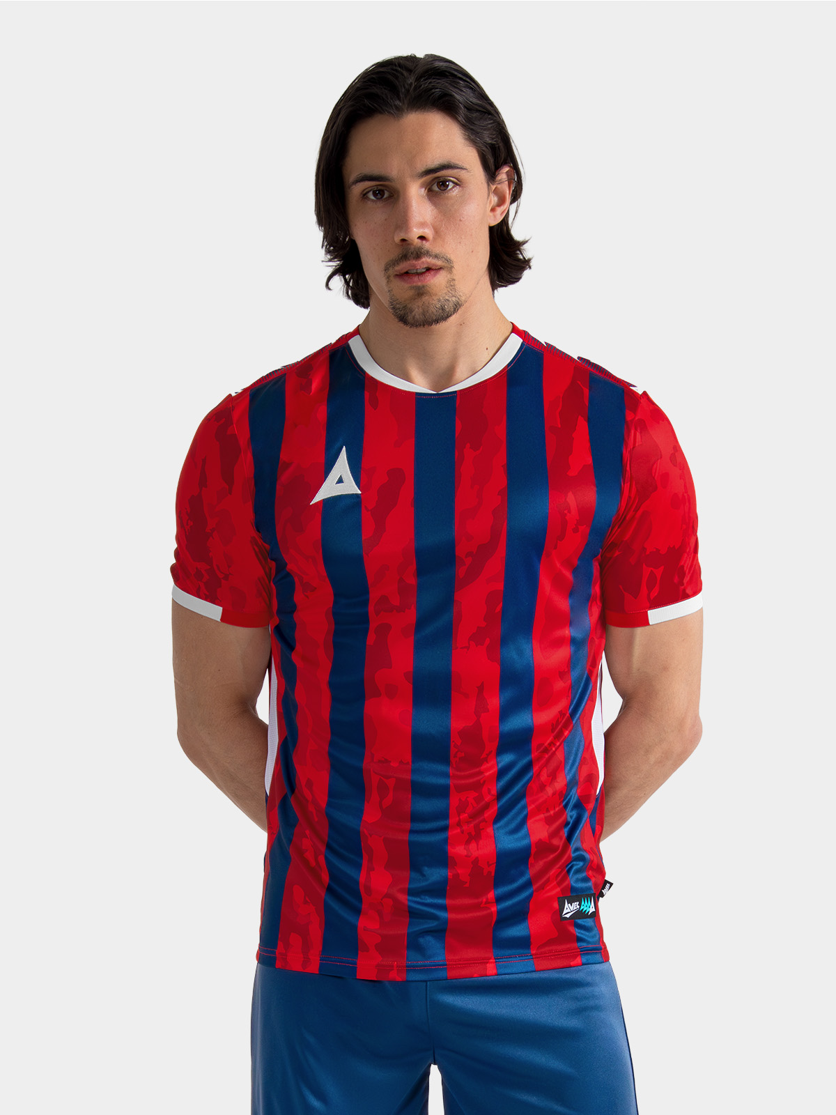 	top-half view of the red, navy, and white team shirt on an adult model, showcasing the professional athletic fit.