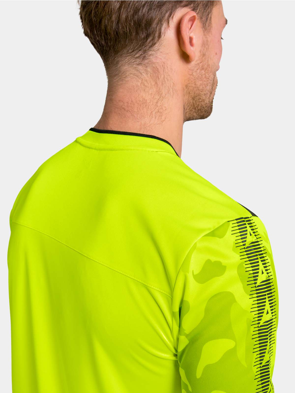 	technical detail of the neon yellow jersey hem, showcasing the woven id label and high-performance mesh