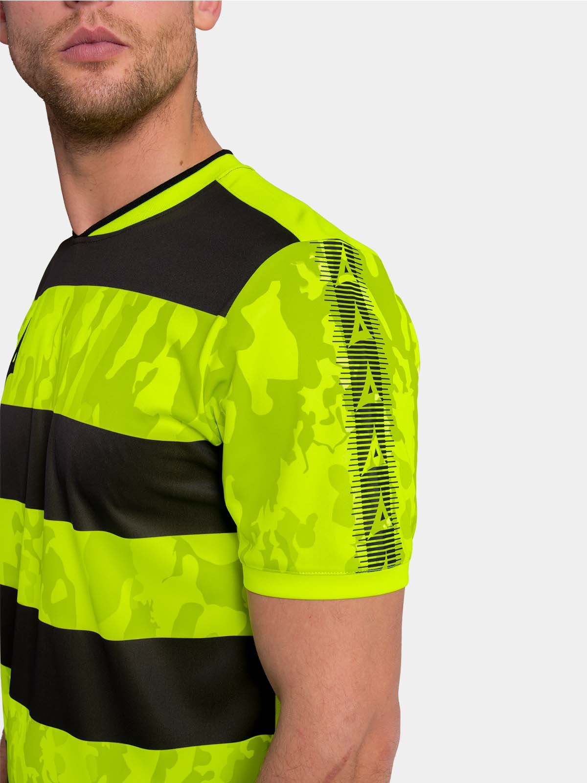	detailed shoulder shot of the neon yellow jersey featuring the black heritage sleeve branding.