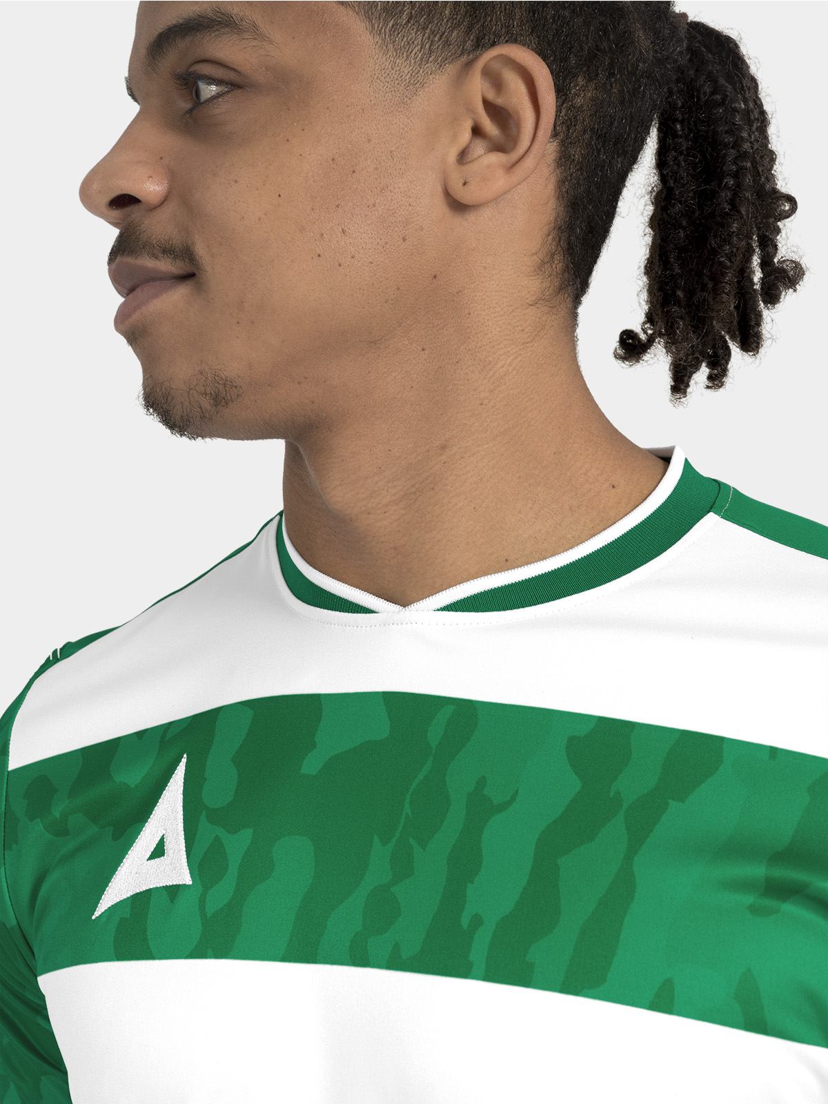 	detail of the v-neck construction and internal branding on the green and white pro intent matchday shirt.