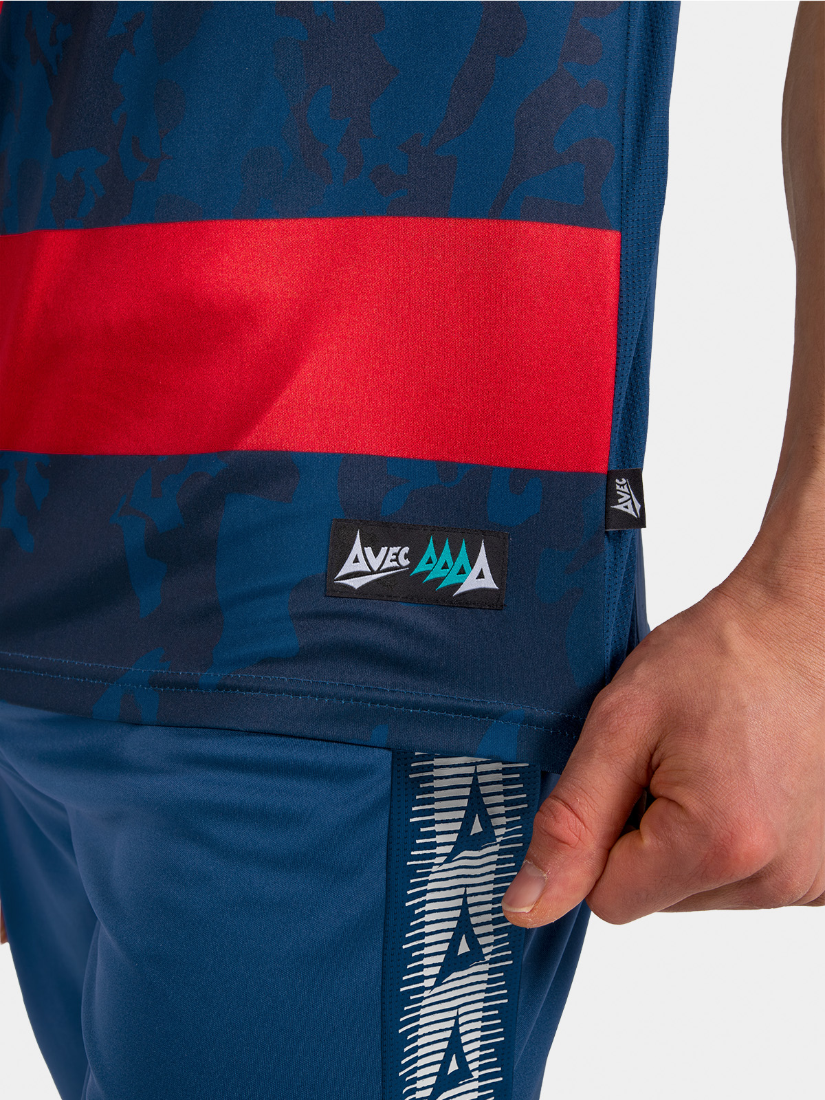 	detail of the navy and red jersey side-seam, showcasing the breathable mesh ventilation and woven hem label.
