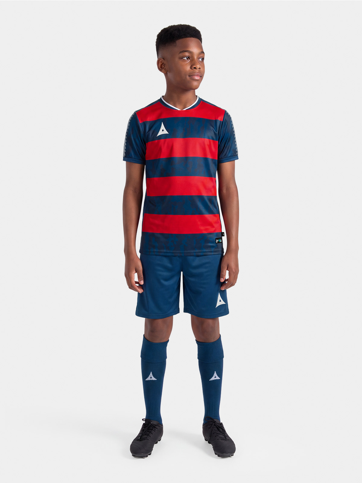 	complete navy and red football kit on-model, demonstrating the professional on-pitch appearance.